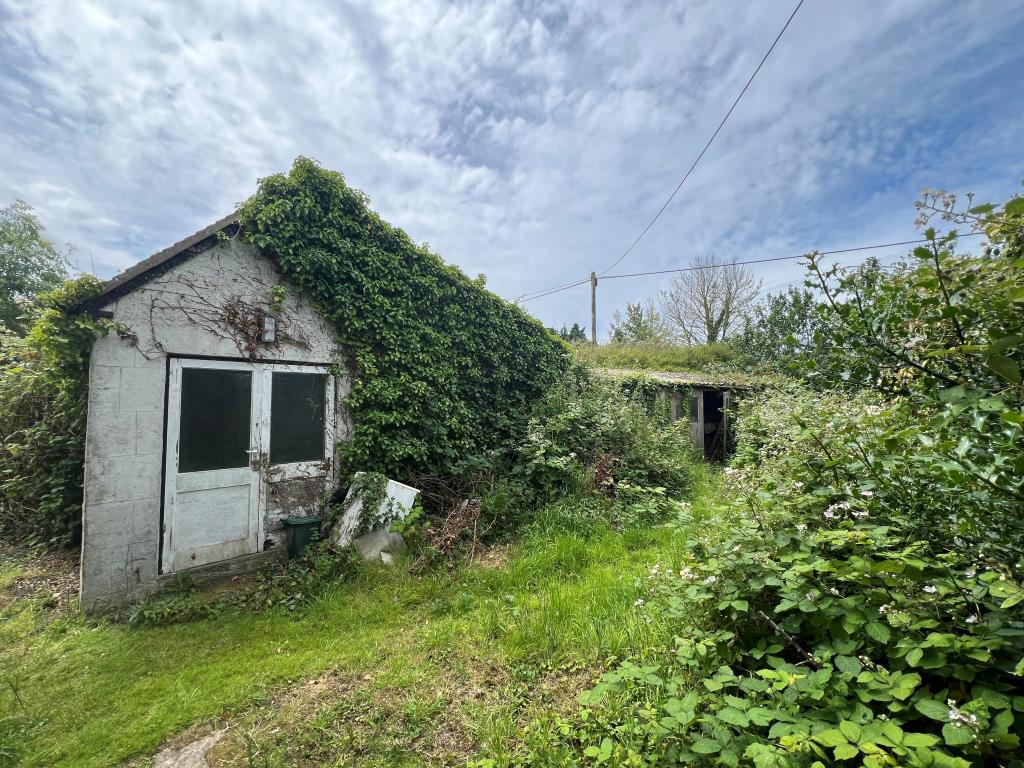 Lot: 128 - THREE-BEDROOM COTTAGE FOR IMPROVEMENT IN POPULAR VILLAGE LOCATION - The workshop to the rear